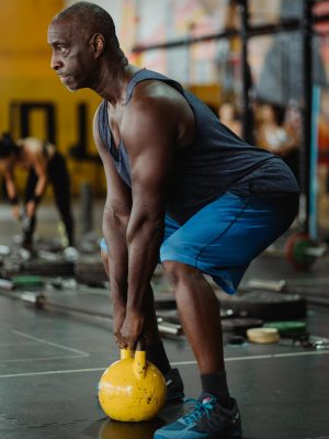 Photo of Man Using Yellow Kettlebell